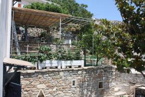 a stone wall with chairs and plants on it at Villa Skamnia in Kinídharos