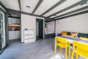 ein Zimmer mit einem Esstisch und gelben Stühlen in der Unterkunft Hedera Sovata 2 in Sovata