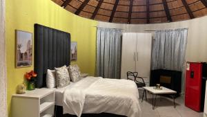 Un dormitorio con una cama, una mesa y un frigorífico. en Harmony Spaces, en Kempton Park 95 fotos más