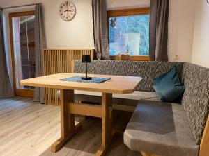 un tavolo di legno con una lampada sopra un divano di Apartment Bergglück Wildschönau a Wildschönau