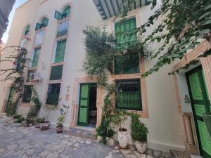 a white building with green doors and potted plants at mahdia old city luxury house in Mahdia