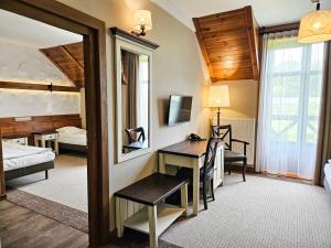 a hotel room with a desk and a bedroom at Folwark Łękuk in Łękuk Mały +241 photos