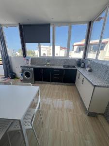 a kitchen with a counter top and some windows at Joli et confortable appartement in Cabo Negro