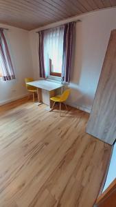 a room with a table and chairs and a window at Einfache 2 Zimmer Wohnung mit Parkplatz nur 8 Min nach Bayreuth in Mistelgau