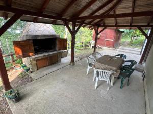 a patio with a table and chairs and a fireplace at Kraljeva breza in Divčibare