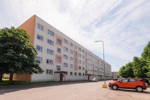 een oranje auto geparkeerd voor een gebouw bij Mainiidu Apartment in Pärnu