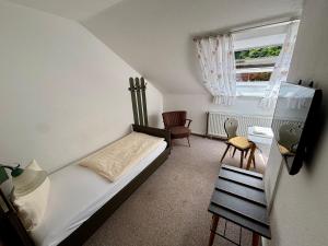 a small bedroom with a bed and a window at Pension & Metzgerei Friedrich in Trebgast