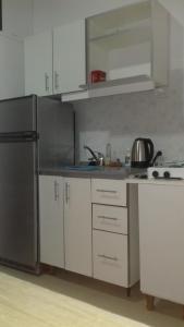 a kitchen with white cabinets and a stainless steel refrigerator at Depto en PH Planta baja al Frente in Buenos Aires