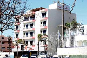 a building with a fountain in front of a building at Hotel Nolasco in Macaé