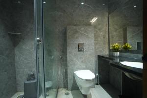 a bathroom with a shower and a toilet and a sink at Hotel Avasa in Tenāli