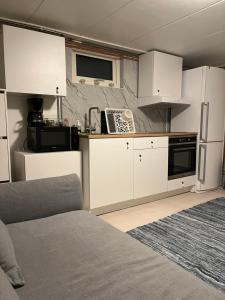 a kitchen with white cabinets and a refrigerator at My little world 2 in Malmö