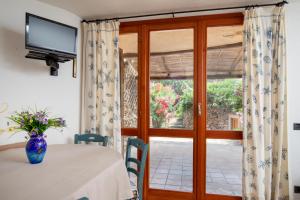 a dining room with a table and a glass door at Casa Irene by Wonderful Italy in Porto Cervo