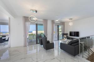 ein Wohnzimmer mit Sofa und Fernseher in der Unterkunft Luxury Paphos Villa Villa Adaris 5 Bedroom Villa Private Swimming Pool in Peyia