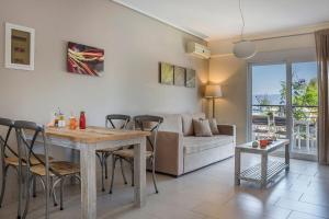 a living room with a table and a couch at Deluxe Kefalonia Apartment Apartment Tangerine 1 Bedroom Pool Sea View Karavomilos in Karavomylos