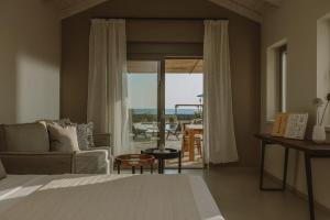 a bedroom with a bed and a living room with a view at Beautiful Preveza Villa Villa Soleil 1 Bedroom Private Pool And Stunning Sea Views Kanali Beach in Preveza