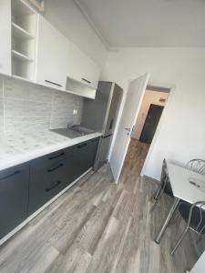 cocina con armarios blancos y suelo de madera en kyr house 3, en Văleni