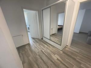 una habitación vacía con un espejo grande en la pared en kyr house 3, en Văleni 2 fotos más
