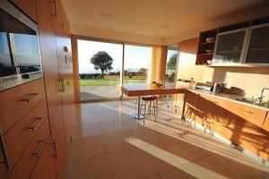 eine Küche mit einer Theke und einem großen Fenster in der Unterkunft Tasteful Caminha Villa 4 Bedrooms Villa Laginhas Modern Furnishings in Caminha