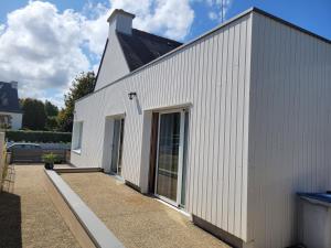 a white building with a large glass door at Maison Ty Pempoul rénovée, Confort, accessibilité et sérénité à Paimpol in Paimpol