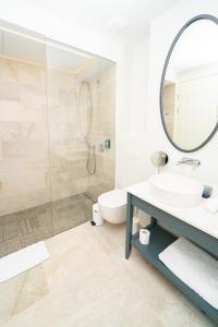 a bathroom with a toilet and a sink and a mirror at One Bedroom Sea View Apartment - Lustica Marina in Radovici +8 photos
