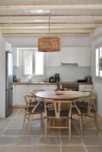 a kitchen with a table and chairs and a chandelier at Luxury Paros Villa Villa Aethra Beautiful & Serene Glisidia in Kampos Paros