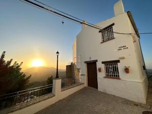 a white building with the sunset in the background at Loft Deluxe Torre del Pan in Olvera