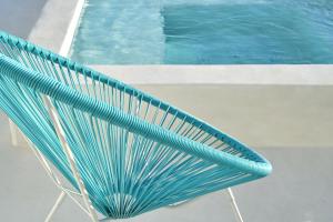 a green bench next to a swimming pool at Luxury Paros Villa Villa Aethra Beautiful & Serene Glisidia in Kampos Paros