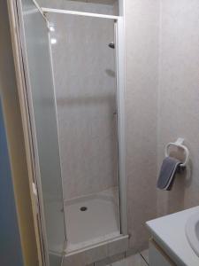 una ducha con puerta de cristal en un baño en Appartement de ville, en Parthenay