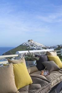a couch with pillows on a balcony with a view at Elegant Astypalaia Villa Villa Bianca 2 Bedrooms Hot Tub & Beautiful Sea in Astypalaia Town