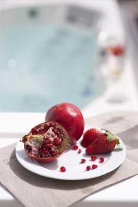 a plate of fruit with strawberries on a table at Elegant Astypalaia Villa Villa Bianca 2 Bedrooms Hot Tub & Beautiful Sea in Astypalaia Town