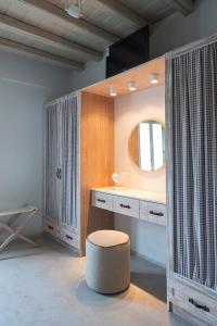 a bathroom with a vanity with a stool and a mirror at Elegant Astypalaia Villa Villa Bianca 2 Bedrooms Hot Tub & Beautiful Sea in Astypalaia Town