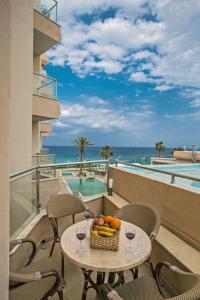 una mesa con una cesta de fruta y copas de vino en el balcón en Apt Lasonos Asimi - Luxury 3 Bedroom Appartment - Protaras Apt With Communal Pool On Fig Tree Bay, en Protaras