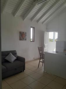 a living room with a couch and a table at Haut de villa paisible pour 4 personnes in Le Moule