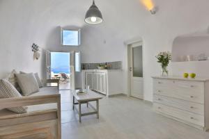 a white living room with a couch and a table at Elegant Santorini House 2 Bedroom Villa Caldera View-Outdoor Hot Tub Oia in Thólos