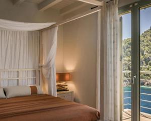 a bedroom with a bed with a view of the ocean at Seafront Kefalonia Villa Villa Kazaana 3 Bedrooms Spectacular Sea Views in Asos