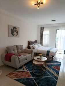 een woonkamer met een bank en een bed bij Cozy Ruaka Retreat in Ruaka +14 foto's