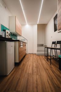 an empty room with a kitchen and a wooden floor at Lùbea Apartment - Vinto House Collections in Salerno