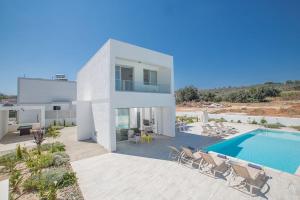 a large white house with a swimming pool at Villa Ochosto Eos - Luxury 5 Bedroom Protaras Villa With Private Pool - Close To The Beach in Protaras