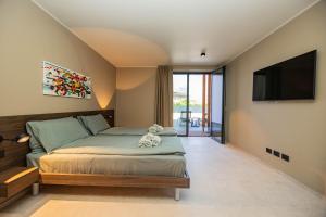 a bedroom with a bed and a flat screen tv at Vinea Rural Resort - Adults only in Arco