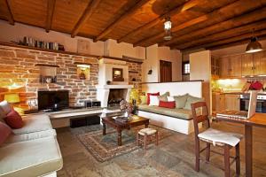 ein Wohnzimmer mit einer Couch und einer Ziegelwand in der Unterkunft Great Pelion Villa Villa Dioni 2 Bedrooms Aghios Georgios in Pilion