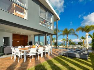 una sala da pranzo all'aperto con tavolo e sedie di Villa Limni Dyo - Luxurious Contemporary 3 Bedroom Villa With Sea Views And Hot Tub a Paralimni