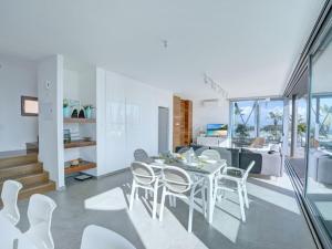 una sala da pranzo e un soggiorno con tavolo e sedie di Villa Limni Dyo - Luxurious Contemporary 3 Bedroom Villa With Sea Views And Hot Tub a Paralimni