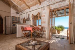 a kitchen and dining room with a table and a view of the ocean at Extravagant Zante Villa Villa Purple Great Sea Views 3 Bedrooms Agios Nikolaos in Koríthion