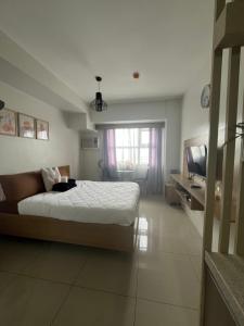 a bedroom with a bed and a television in it at Horizon 101 in Cebu City