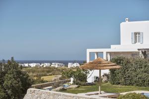 a patio with an umbrella and a white building at Luxury Naxos Villas Luxury Villa Air Conditioning Private Pool 2 Bedrooms Stelida in Naxos Chora