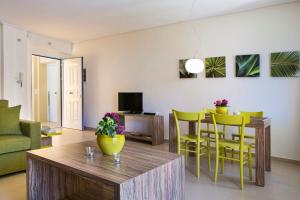 a living room with a table and yellow chairs at Deluxe Kefalonia Apartment Apartment Nectar 1 Bedroom Pool Sea View Karavomilos in Karavomylos