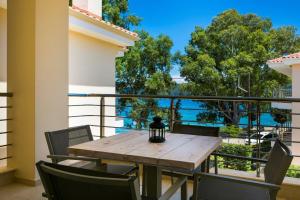 a table and chairs on a balcony with a view of the water at Deluxe Kefalonia Apartment Apartment Nectar 1 Bedroom Pool Sea View Karavomilos in Karavomylos