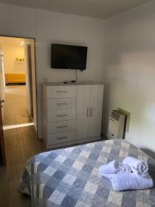 Schlafzimmer mit einem TV und einem Bett mit Handtüchern in der Unterkunft Los Amancay del Otto ventana in San Carlos de Bariloche