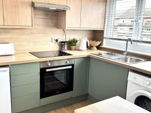a kitchen with a sink and a dishwasher at Almondvale Apartment in Livingston +17 photos