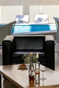 a black leather couch with two bottles and glasses on a table at Illustrious Brac Villa 6 Bedrooms Villa Bol Waterfront Private Pool & Balcony With Beautiful Views Bol in Bol